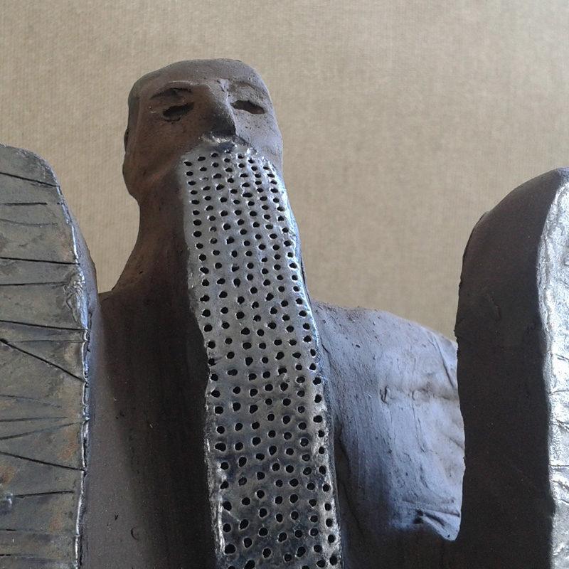 Israeli sculpture: Moses, standing, with the two tablets. Dark brown ceramic sculpture.