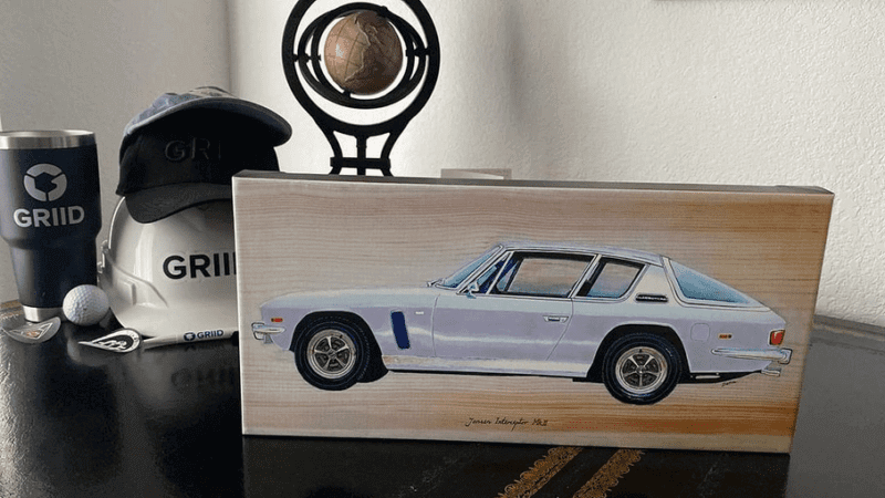 Automotive art: Jensen Interceptor canvas print on a table with golfing mementos