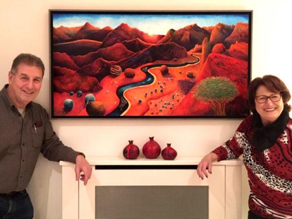 Commissioning art: Happy owners of a new commissioned painting, a red desert painting.