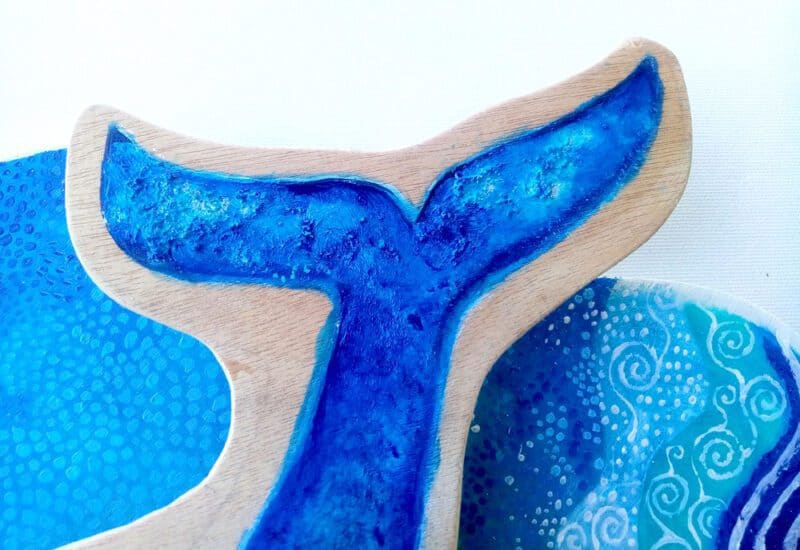 Blue whale; detail of whale art on wood, in blue.